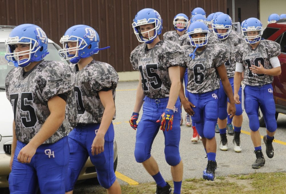 Oak Hill players take the field in their camouflage uniforms before a game against Dirigo last Saturday.