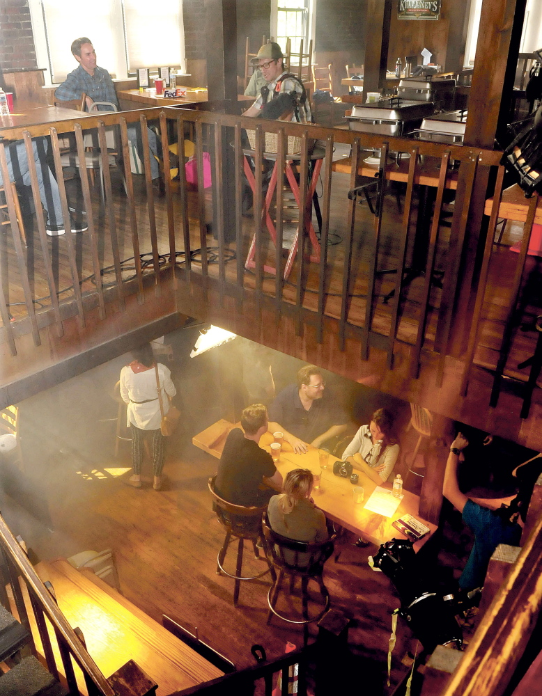 "American Pickers" star Mike Wolfe, top left, extras and production staff fill two floors of the Old Mill Pub in Skowhegan before filming promotional commercials for “American Pickers” and “Down East Dickering.”