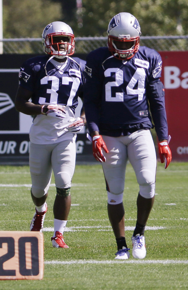 New England Patriots cornerbacks Darrelle Revis (24) and Alfonzo Dennard (37) walk during a stretching session before practice Wednesday in Foxborough, Mass. Revis collected his first interception of the season last week in New England’s win over the Minnesota Vikings.