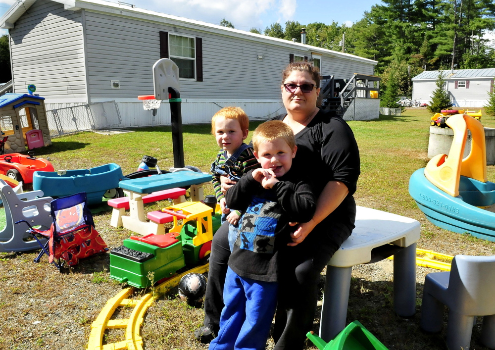 Dawn Zammuto holds her grandchildren Allen, left, and Dominic outside the home she rents in Norridgewock. Zammuto’s landlord started eviction proceedings after her daughter, Jessica Botto, visited with her sevice dog, but decided to stop the process on Thursday.
