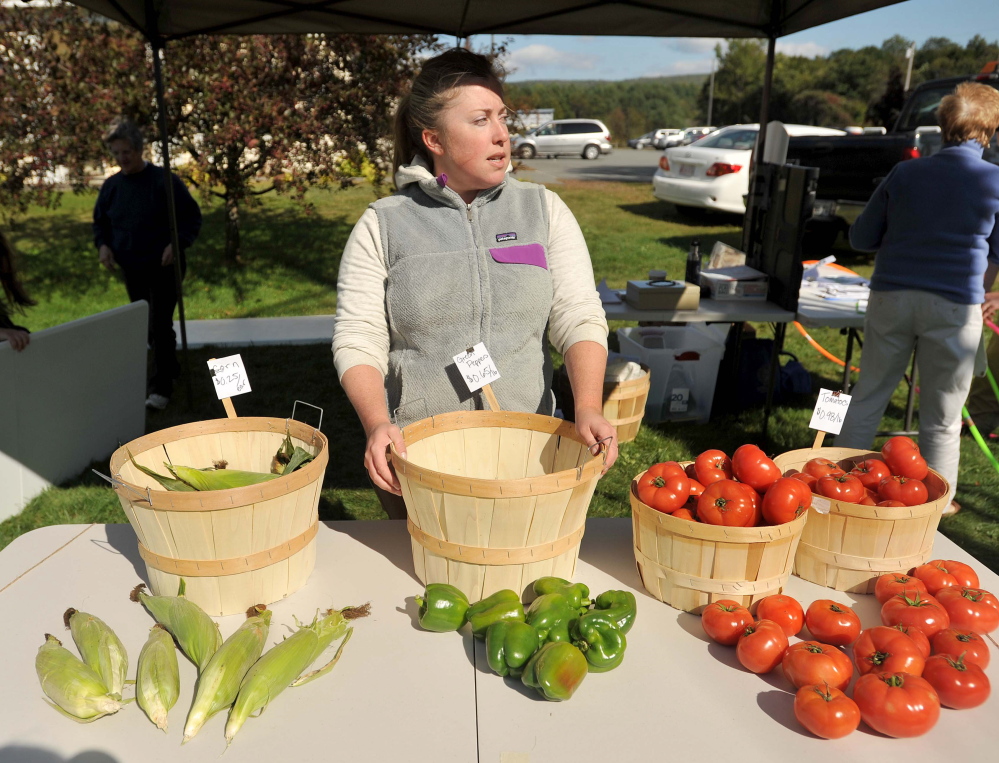 Meghan Quinn, an intern with the Good Shepherd Food Bank, manages the farm stand on Main Street in Bingham on Thursday. The farm stand offers discounted produce and accepts EBT cards.