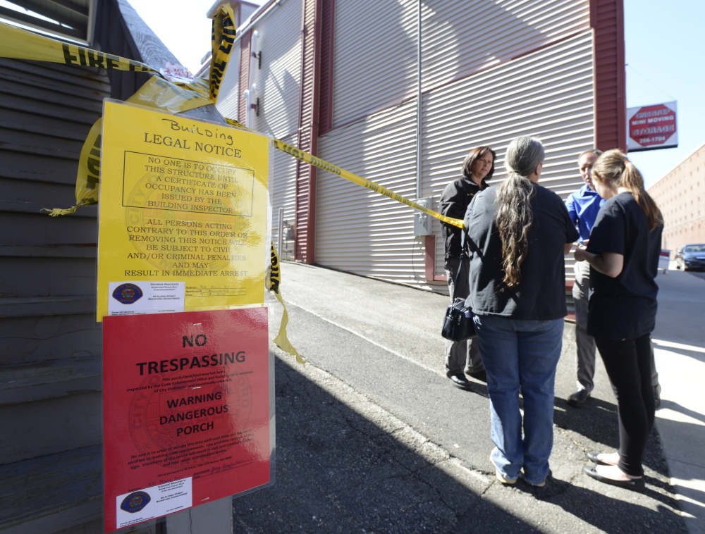 Fire victim Carrie Chenery, center, and granddaughter Keauna Froehlich, 14, talk with state fire investigator Mary MacMaster on Friday as they and other residents try to reclaim personal items from their apartments in Biddeford.