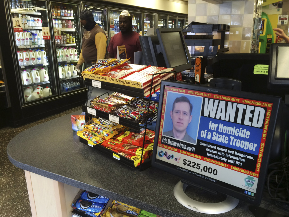 A video display at a convenience store shows a wanted poster of Eric Frein, a 31-year-old from Canadensis, Pa., in Philadelphia. Frein is charged with killing Pennsylvania State Trooper Cpl. Bryon Dickson and wounding Trooper Alex Douglass in a late-night ambush Sept. 12 outside the Blooming Grove state police barracks.
