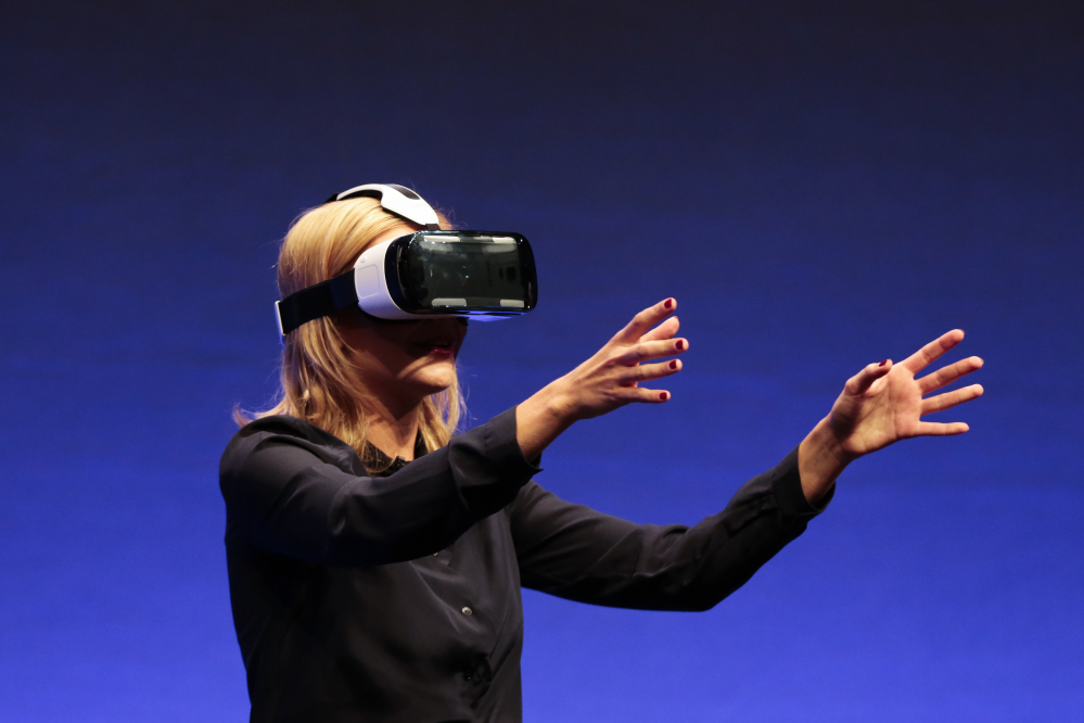 British television presenter Rachel Riley shows a virtual-reality headset called Gear VR during an unpacked event of Samsung ahead of the consumer electronic fair IFA in Berlin. Oculus, the virtual reality company acquired by Facebook earlier this year for $2 billion, is holding its first-ever developers conference and discussed the much-anticipated release of its VR headset for consumers.