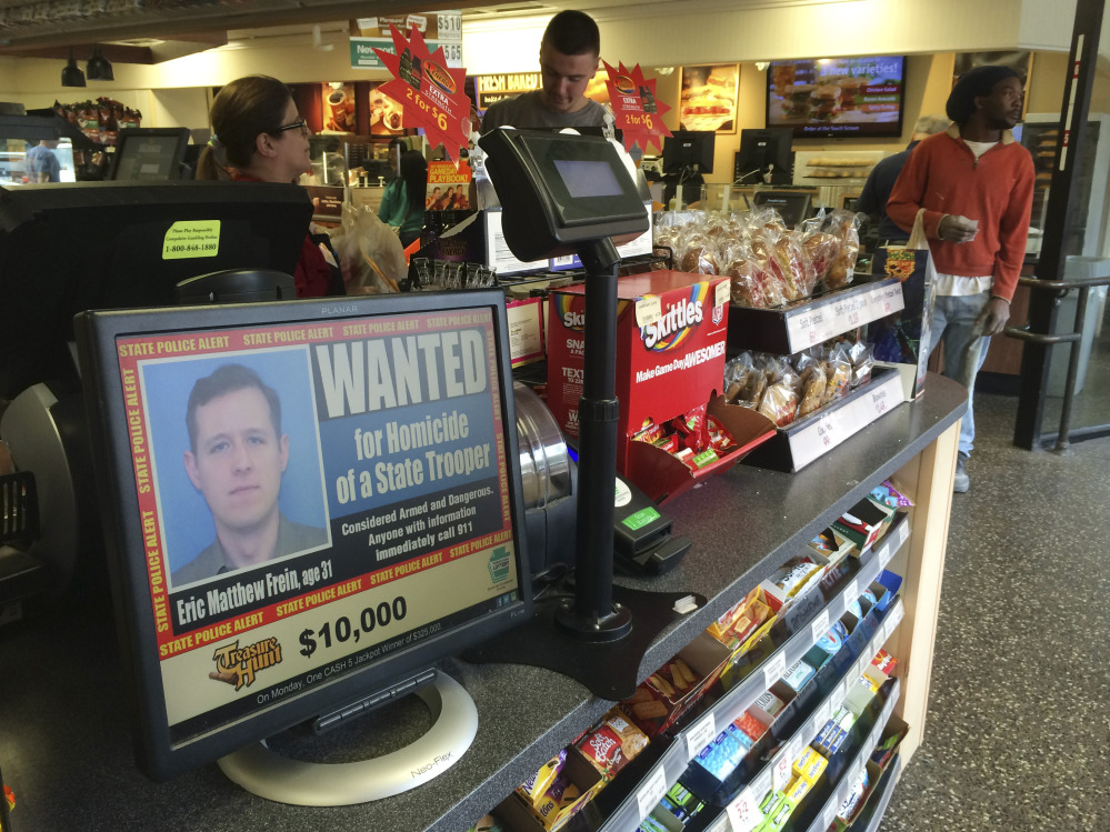 A video display at a convenience store shows a wanted poster of Eric Frein, a 31-year-old from Canadensis, Pa., Friday, in Philadelphia.