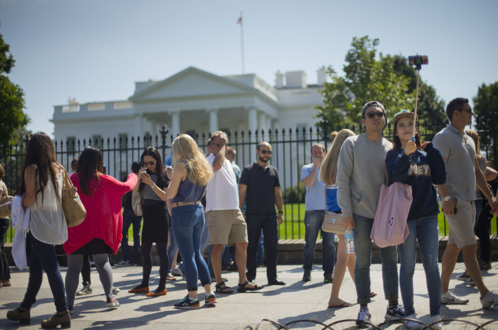 Tourist stop to take their photograph in front of the White House in Washington, Saturday.  The Secret Service is coming under renewed scrutiny after a man scaled the White House fence and made it all the way through the front door before he was apprehended.