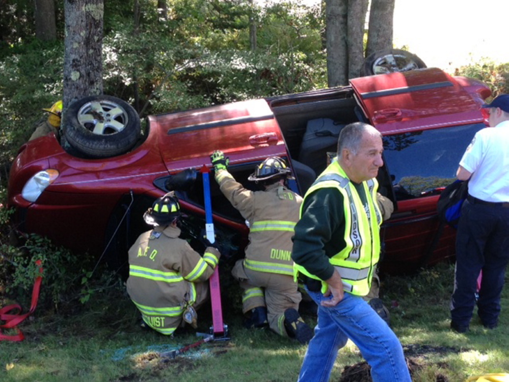Windsor and Augusta firefighters prepare to extricate one of two women trapped in a van that rolled over Monday on Route 17 in Windsor. Police said Tuesday the driver is likely to face charges.