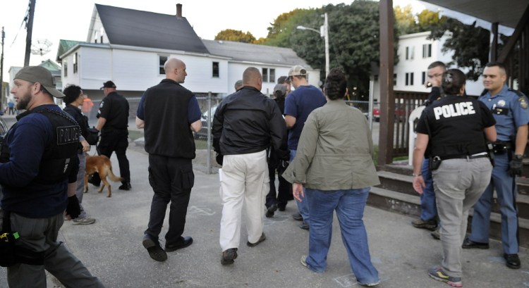 Federal, state, county and corrections officers arrive at an apartment in Augusta Thursday while assisting the city’s police in checking on a resident on probation during a coordinated sweep through the community.