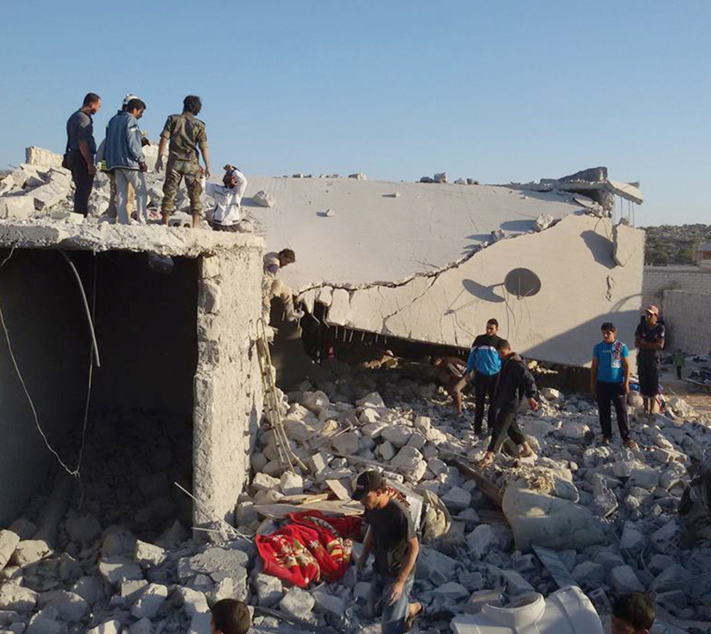 Syrians examine the rubble of a building in the village of Kfar Derian, Syria, that was leveled by coalition airstrikes during Tuesday’s bombardment of Islamic State and Khorasan Group forces.