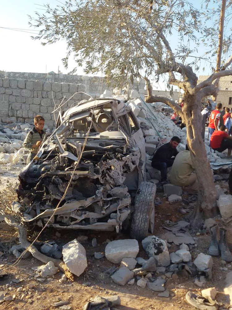 A Syrian boy examines a car destroyed in Tuesday’s airstrikes. Coalition aircraft and Tomahawk missiles struck 22 targets used by Islamic State and Khorason forces.