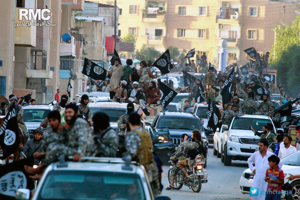 In this undated image posted on June 30, 2014, by the Raqqa Media Center of the Islamic State group, which has been verified and is consistent with other AP reporting, fighters from the Islamic State group parade in Raqqa, north Syria.