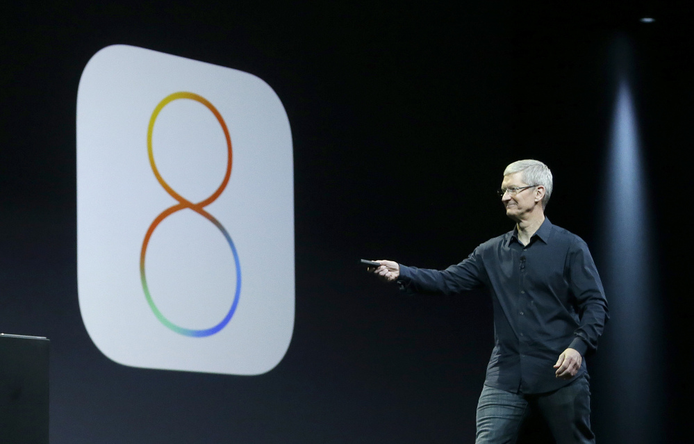 Apple CEO Tim Cook speaks about iOS 8 in June. Apple stopped providing an update to its new iOS 8 mobile operating software Wednesday after getting complaints.