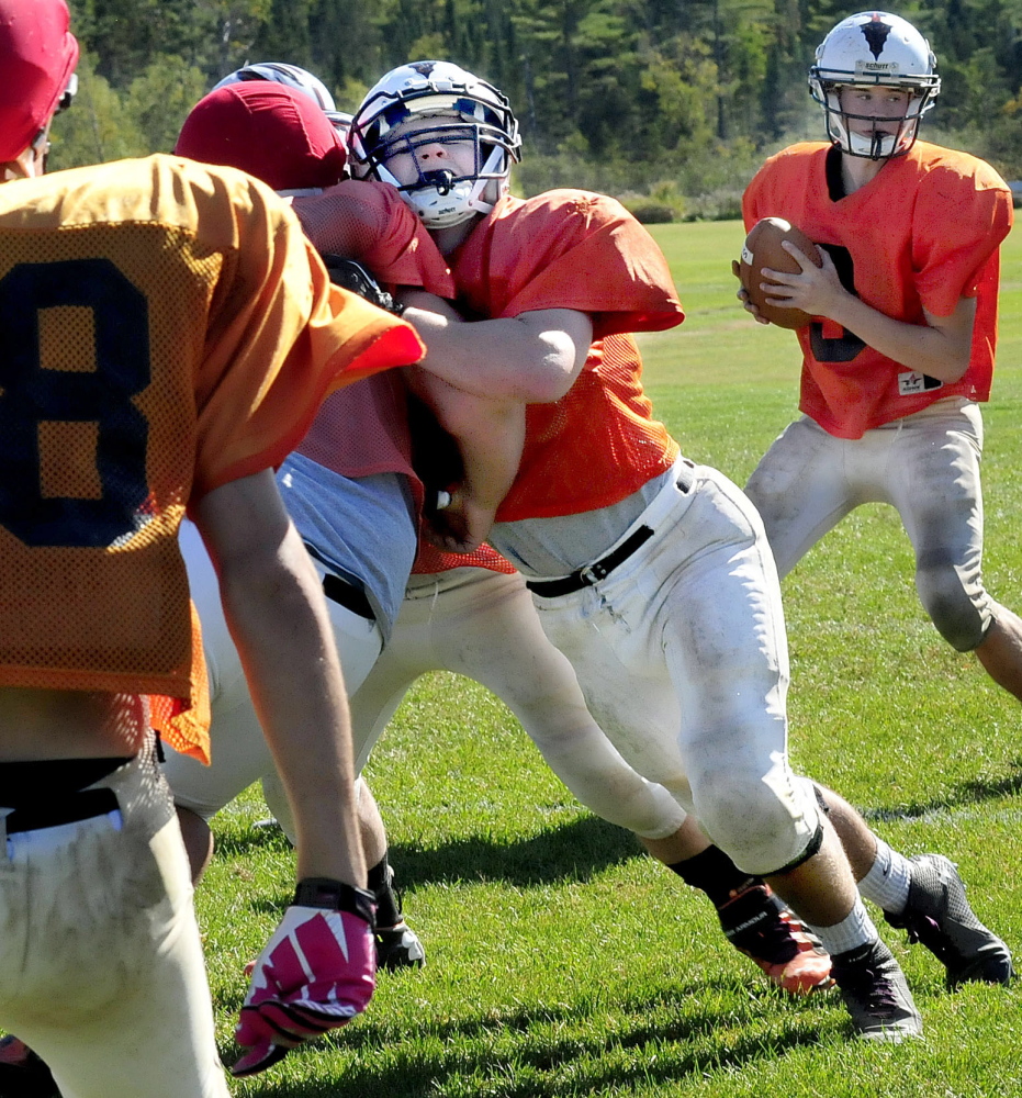 Skowhegan Area High School football player Gus Benson, center, blocks during during practice on Wednesday. Benson, a linebacker on defense, has 58 tackles in three games.