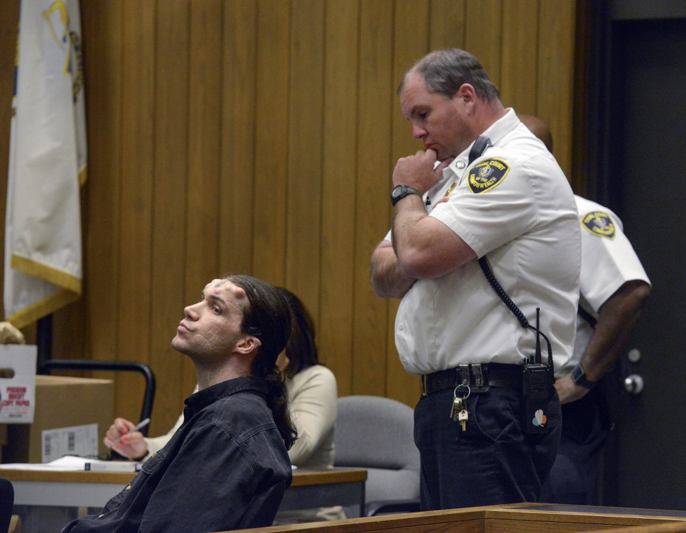 Caius Veiovis, seated, reacts to guilty verdicts in his triple murder trial in Hampden Superior Court Friday in Springfield, Mass. Veiovis is the third of three defendants charged with the 2011 killings of David Glasser, Edward Frampton and Robert Chadwell, of Pittsfield, Mass.