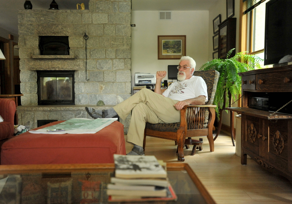 Craig Dickstein, of The Forks, sits in the living room of his home which is divided by the town line of Caratunk and The Forks. Dickstein is part of an effort for Pleasant Pond to secede from The Forks and become part of Caratunk.