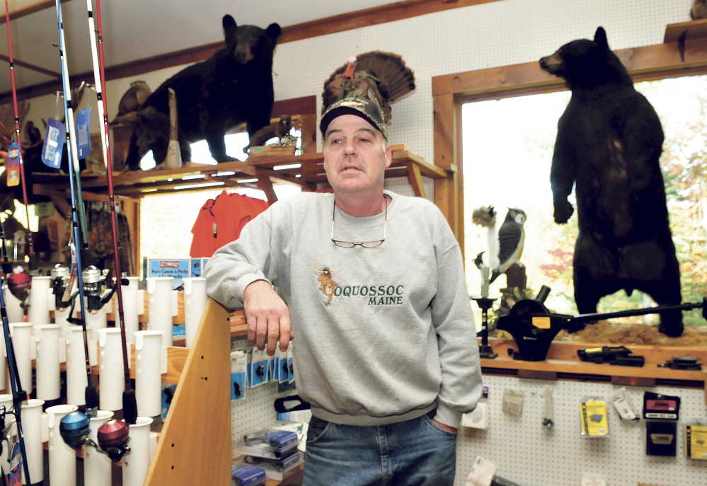 Gerald White stands in his sporting goods store Rivers Edge Sports in Oquossoc surrounded by fishing gear and two stuffed black bears. White said if the bear referendum were to pass this November it would have a devastating impact on his business and others that depend on the season. “There is no question it would hurt business and we would never recover,” White said.