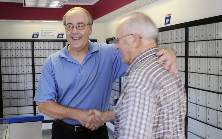 David Shepherd, left, is congratulated Monday by customer Dick Poulin on his retirement from the East Winthrop Post Office. Shepherd is retiring Tuesday after a 35-year postal career.