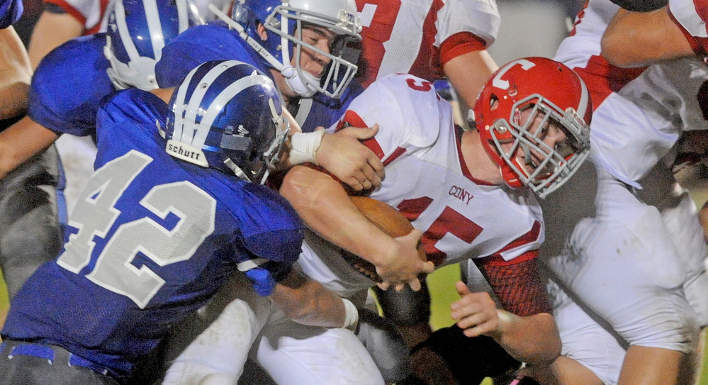 Cony High School quarterback Mitchell Caron (15) drives through the line on the quarterback keeper against Lawrence High School on Friday in Fairfield. The Bulldogs are 3-1 and in second place in Pine Tree Conference Class B while Cony is 2-2 along with four other teams.