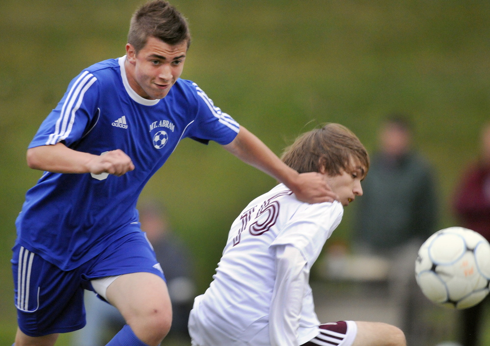 Mt. Abram’s Bryson Walker, left, pushes Monmouth Academy’s Ben Bolstridge during a soccer game Monday in Monmouth.