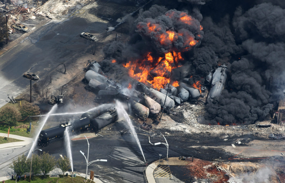 Smoke rises from railway cars carrying crude oil that derailed in downtown Lac-Megantic, Quebec, in July 2013. That was the worst of recent oil train accidents that have prompted proposed new safety rules.