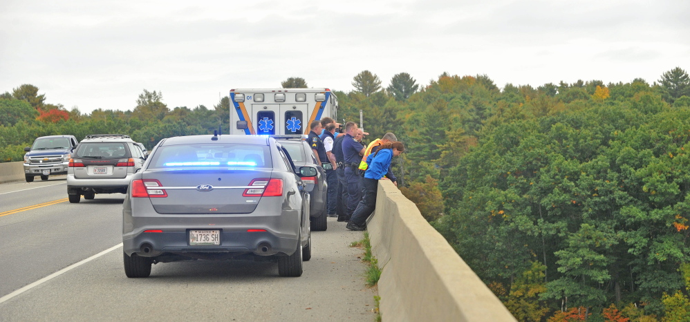 Rescue workers and police from Waterville and Winslow look for a woman who jumped from Carter Memorial Bridge on the Winslow and Waterville town line on Tuesday.