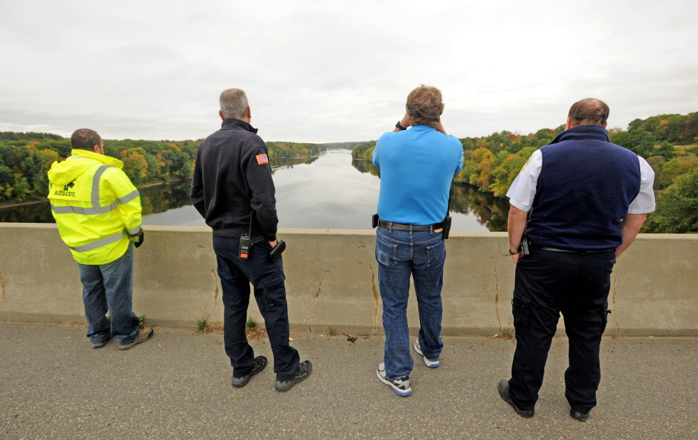 Lt. Scott Holst, right center, with the Waterville Fire Department spots a woman who jumped from Carter Memorial Bridge into the Kennebec River from the bridge on the Winslow and Waterville town line just before 2pm on Tuesday.