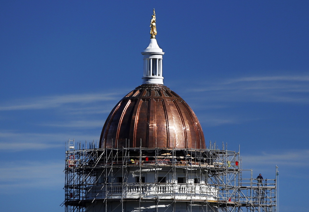 The new copper sheath shines on the State House dome during construction last month. Legislative leaders left a time capsule under the new copper.