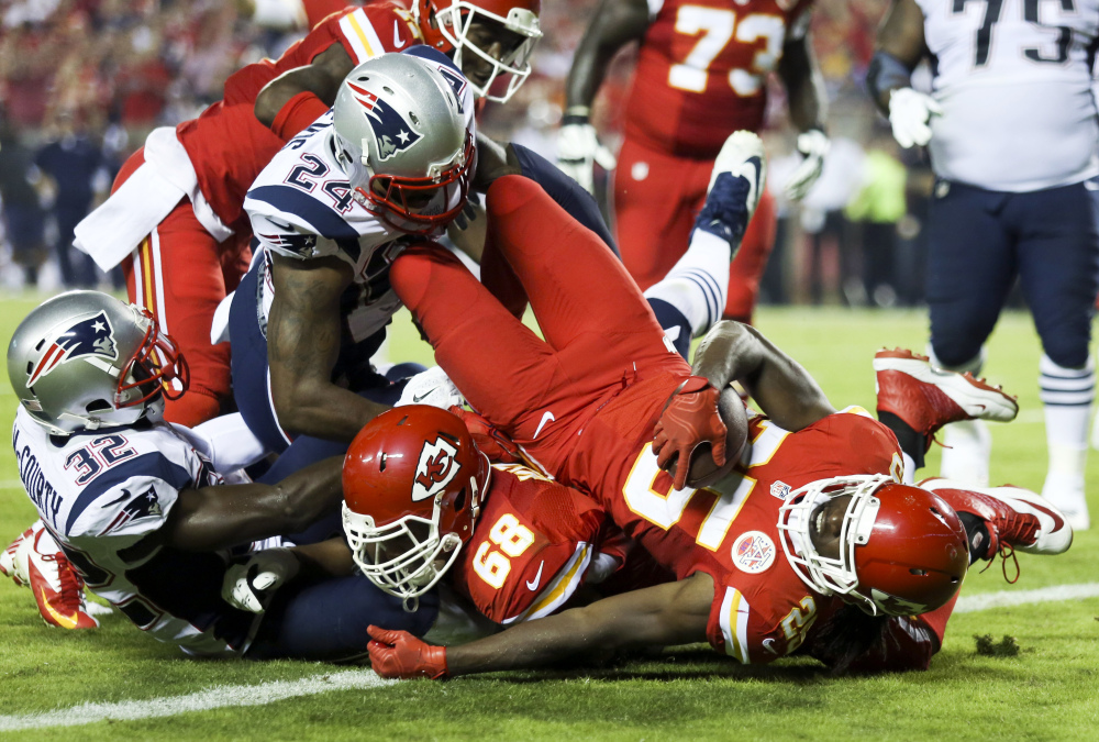 Kansas City Chiefs running back Jamaal Charles, front right, falls into the end zone after catching a 5-yard pass for a touchdown during the second quarter Monday night against the New England Patriots in Kansas City, Mo. The Chiefs won 41-14.