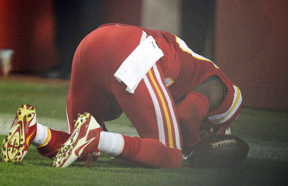 Kansas City Chiefs free safety Husain Abdullah prays after intercepting a pass and running it back for a touchdown during the fourth quarter Monday night against the New England Patriots in Kansas City, Mo. The NFL said Tuesday that Abdullah should not have been penalized for unsportsmanlike conduct when he dropped to his knees in prayer after the interception.