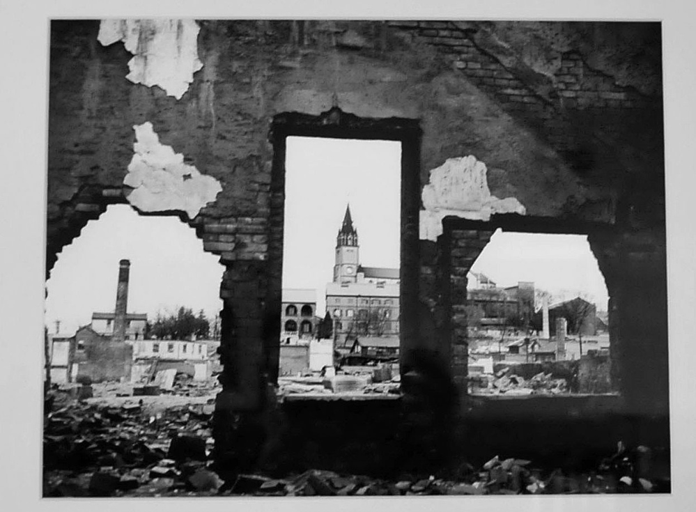 A church in background is seen through the bombed remains of a home in Korea and part of an photo exhibit taken by Galen Leavitt. It is on exhibit at the Oakland Library beginning Wednesday.