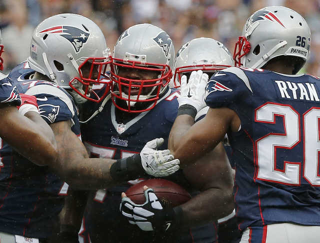 New England Patriots defensive tackle Dominique Easley, left, and cornerback Logan Ryan (26) congratulate defensive tackle Vince Wilfork, center, on his interception in the fourth quarter Sunday against the Oakland Raiders in Foxborough, Mass. The Patriots won 16-9. 