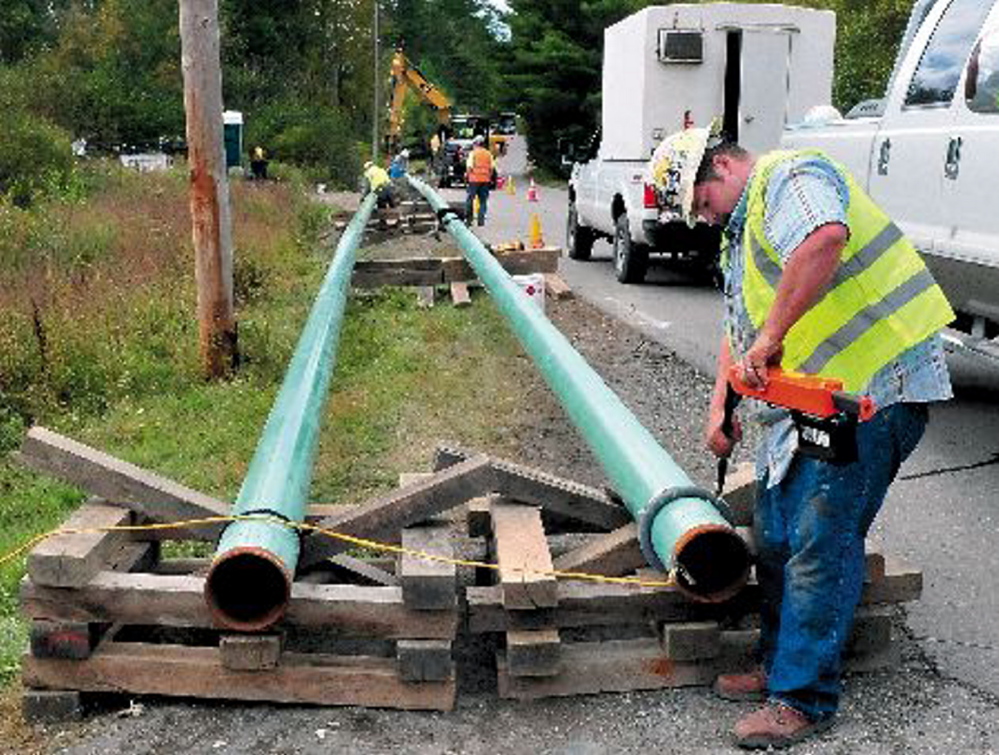 Jeremy Clubbs, of subcontractor U.S. Pipelines, works to install gas pipeline sections in September 2013 outside the Sappi paper mill in Skowhegan. Operators of central Maine’s paper mills say access to natural gas is critical to controlling energy costs.