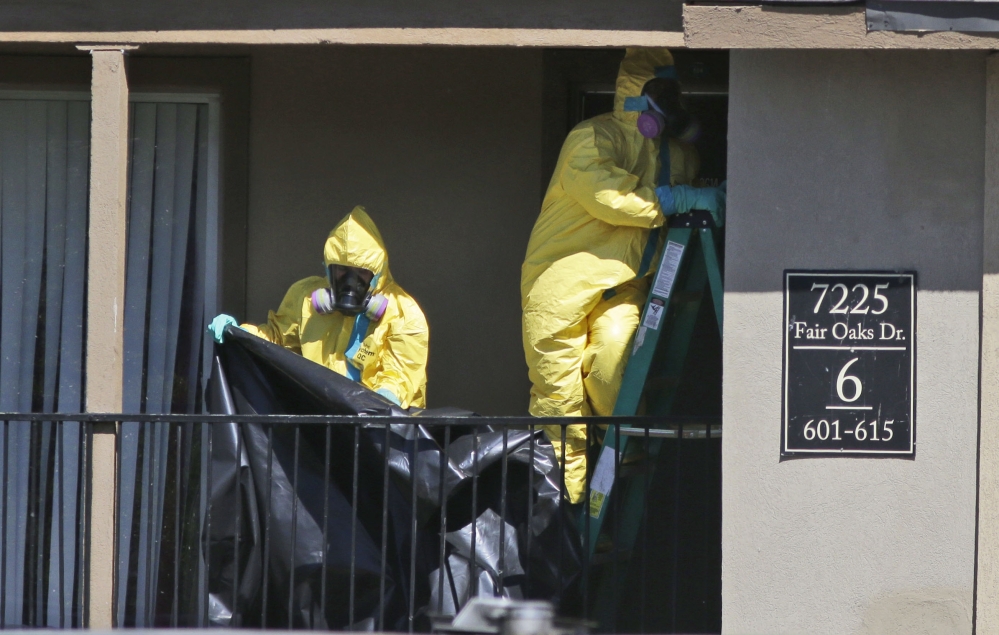 Hazardous material cleaners prepare to hang black plastic outside the apartment in Dallas, Friday, where Thomas Eric Duncan, the Ebola patient who traveled from Liberia to Dallas stayed last week.