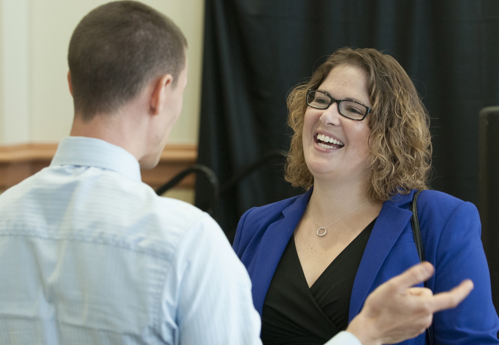 Emily Cain talks with Jonathan Bench during a candidate luncheon in September for Fusion Bangor, a business organization, at the Cross Insurance Center in Bangor.