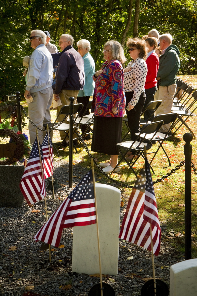 People pledge the flag at Grand Trunk Cemetery in Portland during a dedication of a memorial stone for the early settlers of East Deering.