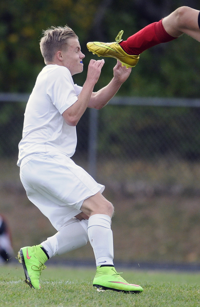 Erskine Academy’s Sam Wilkinson narrowly averts the cleat of Camden’s goalie Lucas Boetsch during a Kennebec Valley Athletic Conference Class B game Tuesday.