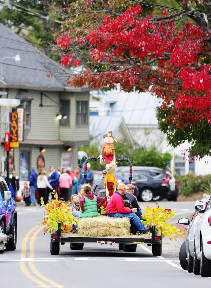 A tractor-drawn hay ride rolls under red foliage through Belgrade Lakes village on Saturday during the Belgrade Harvest Festival.