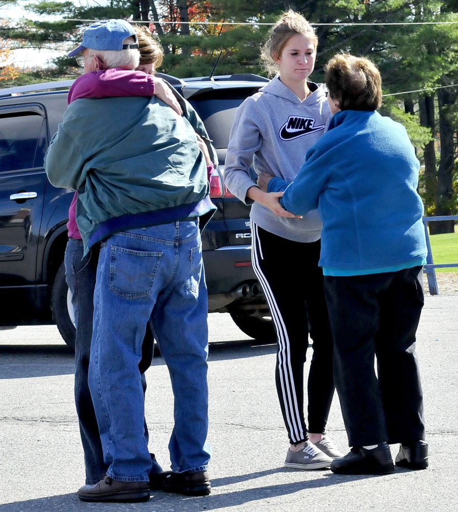 People console each other outside Messalonskee High School in Oakland on Sunday after a gathering of Messalonskee girls soccer team members. Teammate Cassidy Charette died in a hayride accident Saturday in Mechanic Falls.