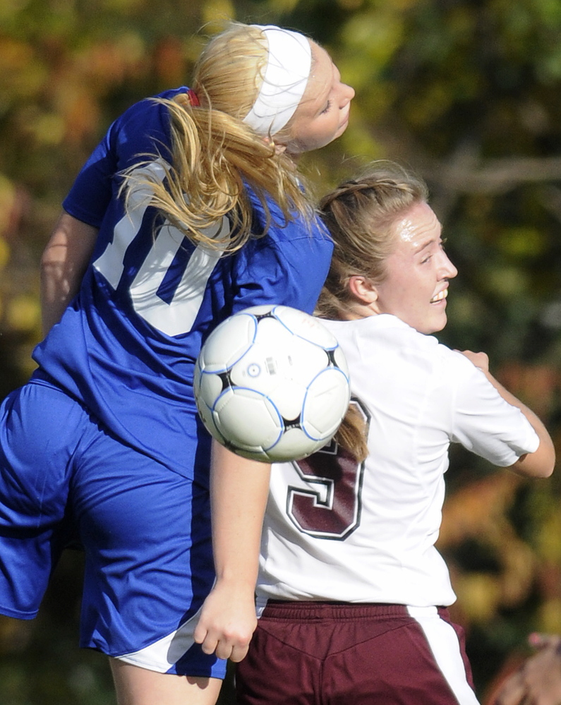 Monmouth Academy’s Madison Bumann, right, goes head-to-head with Madison Area Memorial High School’s Madeline Wood Monday in Monmouth.
