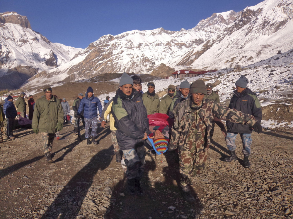 Nepalese army soldiers carry an avalanche victim before he is airlifted in Thorong La pass area, Nepal