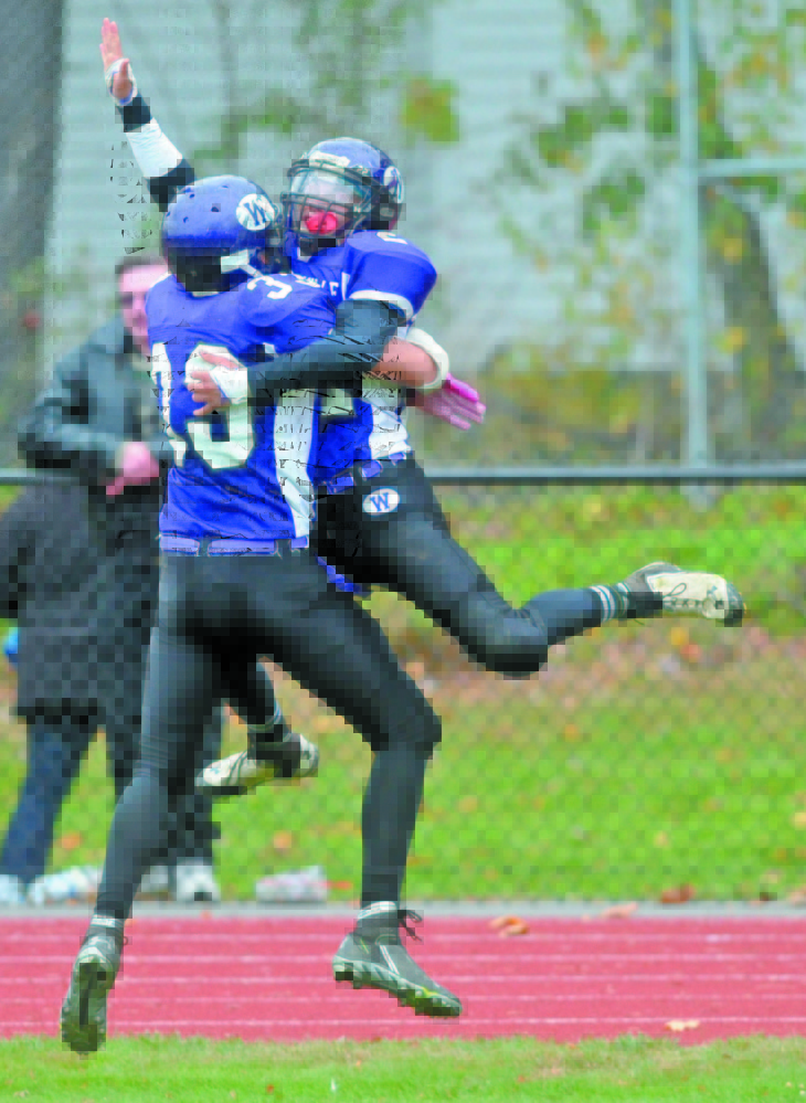 Waterville Senior High School’s Dalton Denis (22) right, celebrates with teammate Troy Gurski (33) after his touchdown catch to win the Battle of the Bridge against Winslow High School last year in Waterville. The two teams meet Saturday at Poulin Field in Winslow