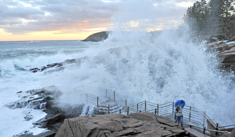Ashlee Stradtman and Justin Downs brace themselves as a wave crashes in to Thunder Hole at Acadia National Park in Bar Harbor on Sunday, Jan. 12, 2014. This picture wone first place at the MPA awards for best scenic photo.