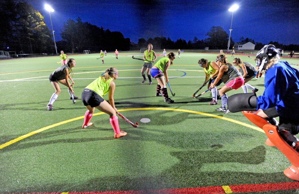 The Winslow High School field hockey team practices on the artificial turf last week at Thomas College in Waterville. More and more teams are looking to practice or play games on turf .