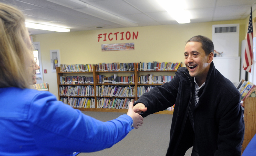 Nate Kenyon greets Dresden Elementary School librarian Laura Lynch on Monday in the Kenyon Center for Arts and Literacy, a modular structure that received a substantial gift from a fund started by the parents of Nate Kenyon.