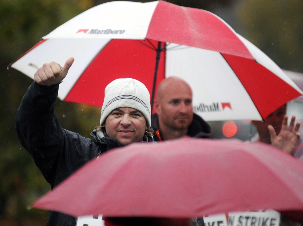 FairPoint Communications workers greet supporters while picketing Tuesday in the rain at the company’s office in Augusta. The phone technicians and clerks are committed to picketing all week despite a forecast for heavy rain , according to Luke Bean, a union member who is out on strike.
