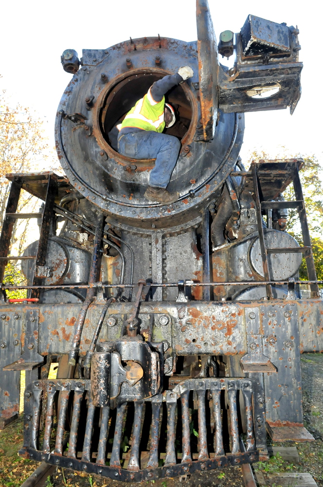 Peter Violette, of New England Steam Corp., inspects the Old 470 steam locomotive smoke box Monday in Waterville. The Waterville landmark is expected to be restored and eventually operative.