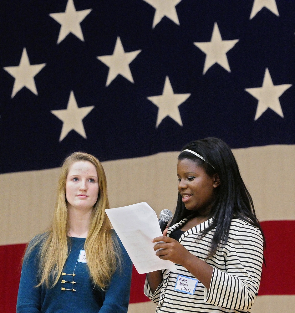Greater Portland Christian School student Jess Smith, left, and Kyrie Austin read out results during the mock election rally and tally event on Wednesday at the Augusta Armory.