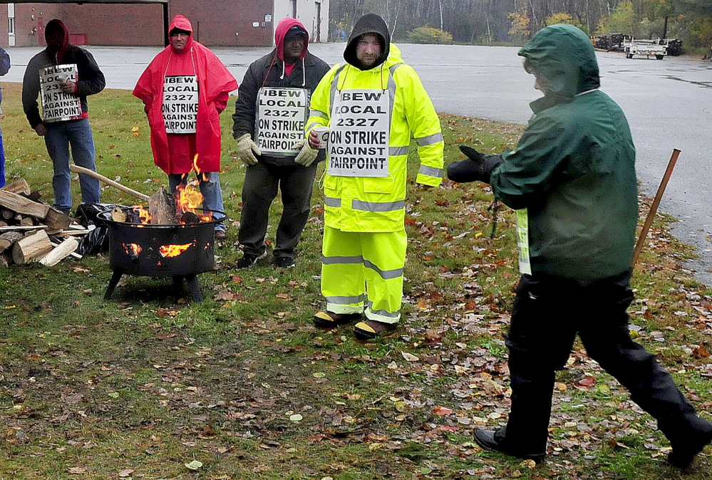 FairPoint company employee Norm Martitz, second from right, greets an employee who arrived to join others picketing outside the company in Waterville on Thursday.
