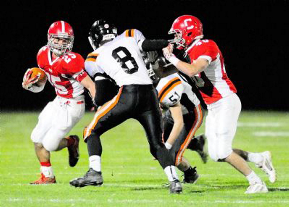 Cony’s Tayler Carrier (25) looks for running room as Gardiner’s Josh McKelvey (8) and Adrian Heath (51) close in. The teams will play in the 137th meeting between the schools Friday at Hoch Field in Gardiner.