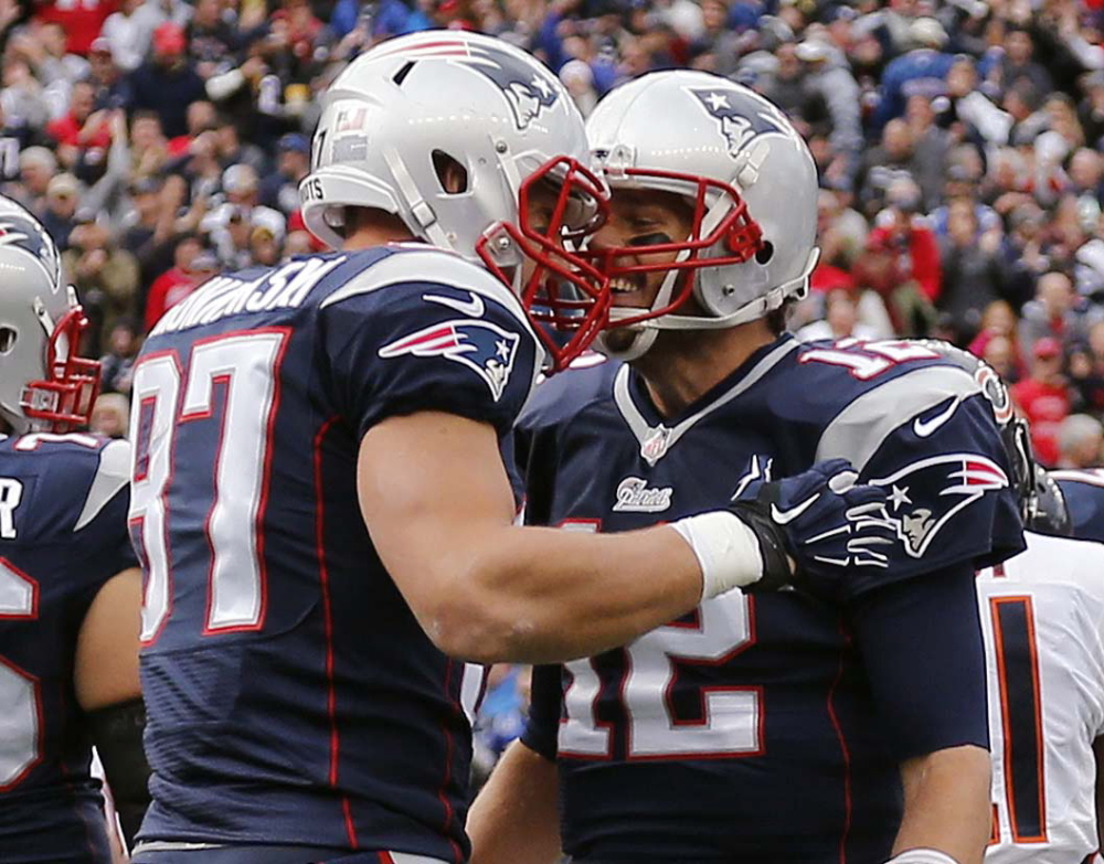Tom Brady, right, celebrates his touchdown pass to tight end Rob Gronkowski in the first quarter Sunday at Gillette Stadium in Foxborough, Mass. Gronkowski scored three TDs in the 51-23 win.
